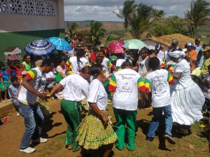 comunidade aguarda o início da solenidade com representantes da Secretaria de Estado de Direitos Humanos brincando o Samba de Roda
