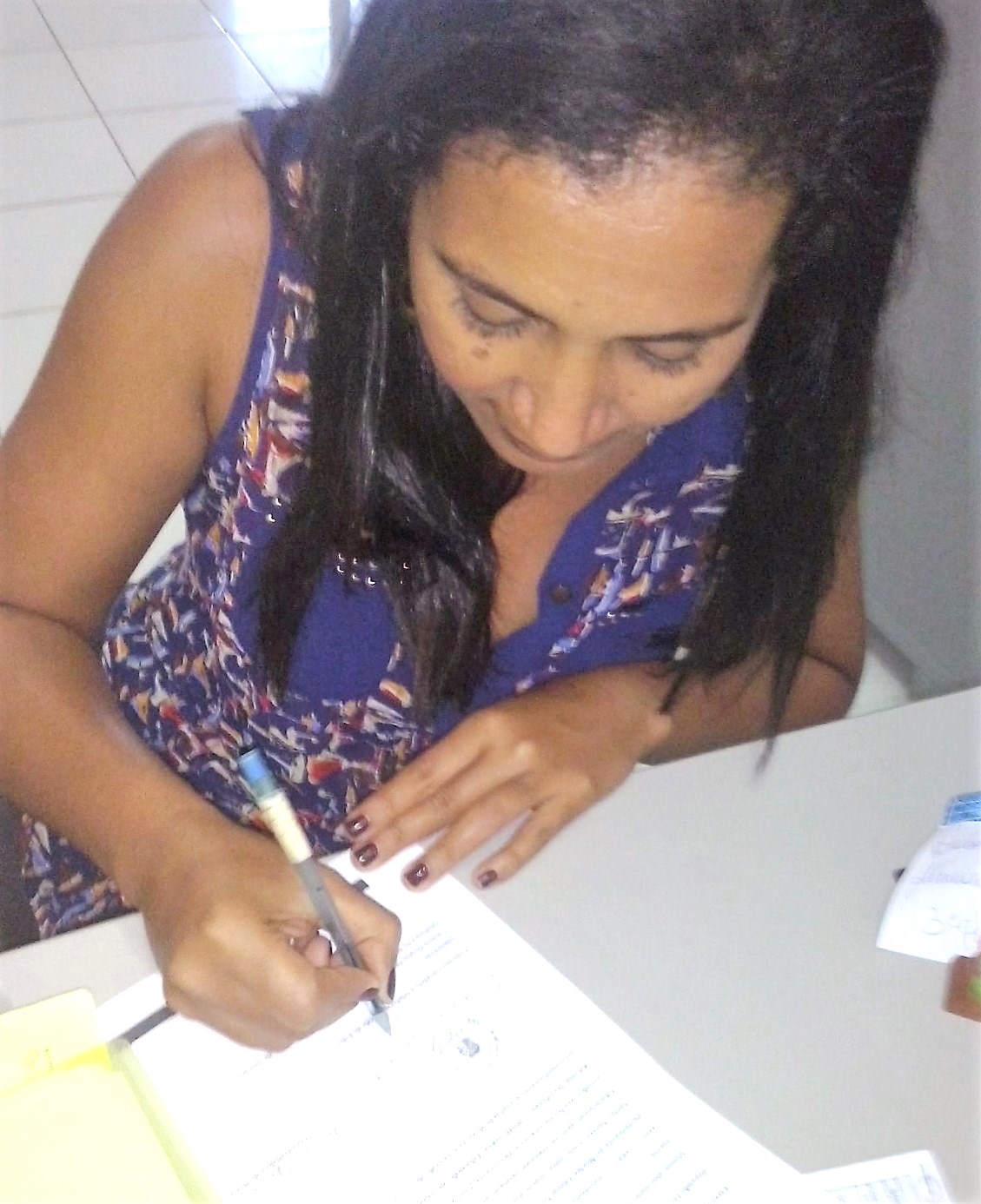 Cristiane Santana, vice-diretora, assinando a Declaração de encaminhamento Turma Sambaituba
